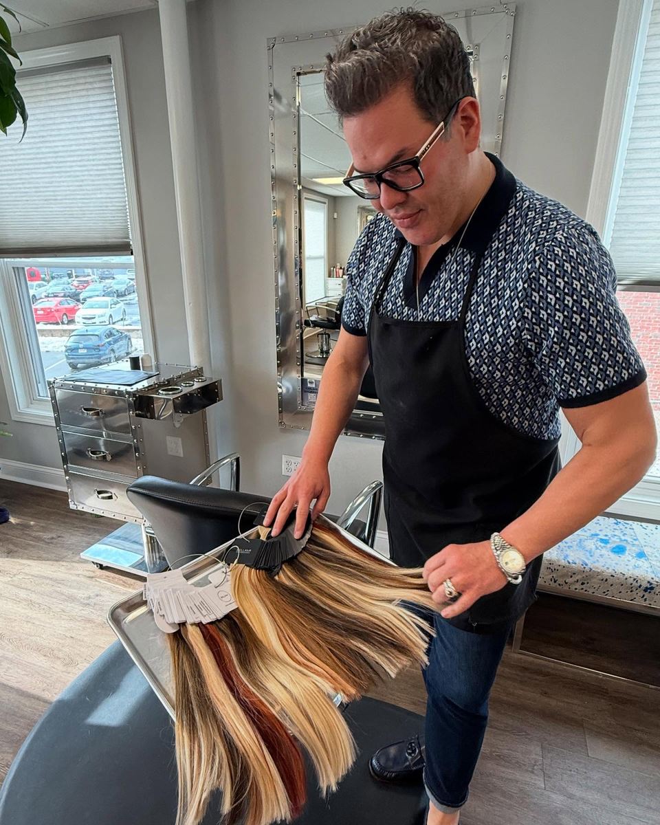 H2T stylist matching hidden weft extensions to a client's color using a hair extension swatch ring in the Foxborough salon